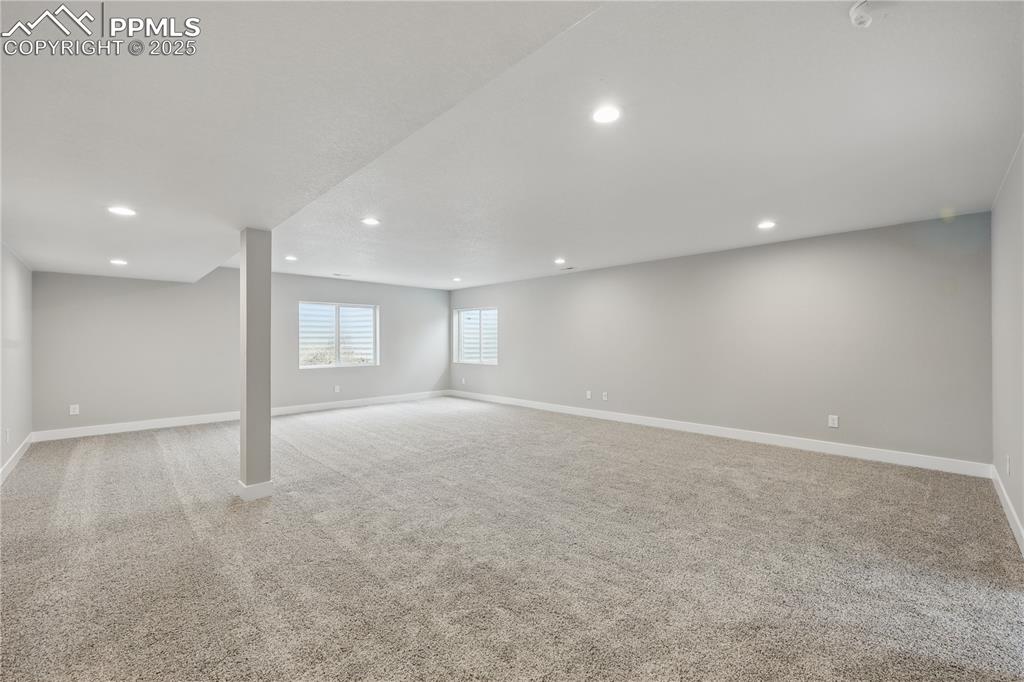 Image 25 of 35: Basement with recessed lighting and baseboards