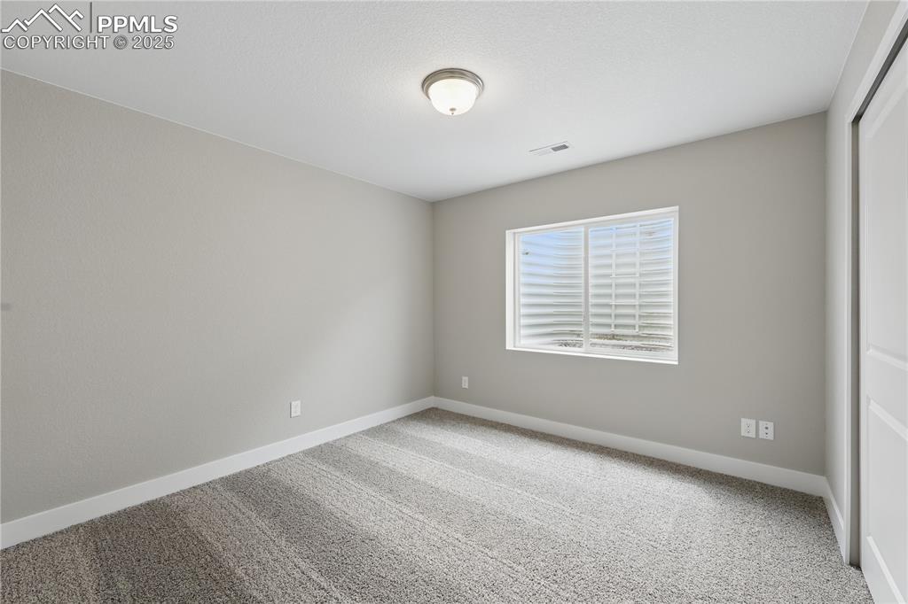 Image 27 of 35: Spare room featuring visible vents, carpet flooring, and baseboards