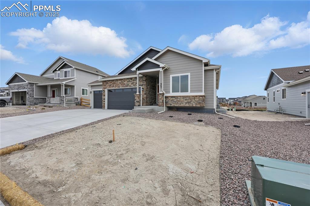 Image 3 of 35: Craftsman-style house with driveway, a porch, an attached garage, and stone