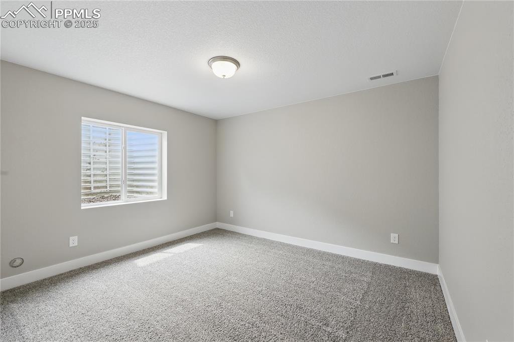 Image 32 of 35: Spare room featuring visible vents, carpet floors, and baseboards