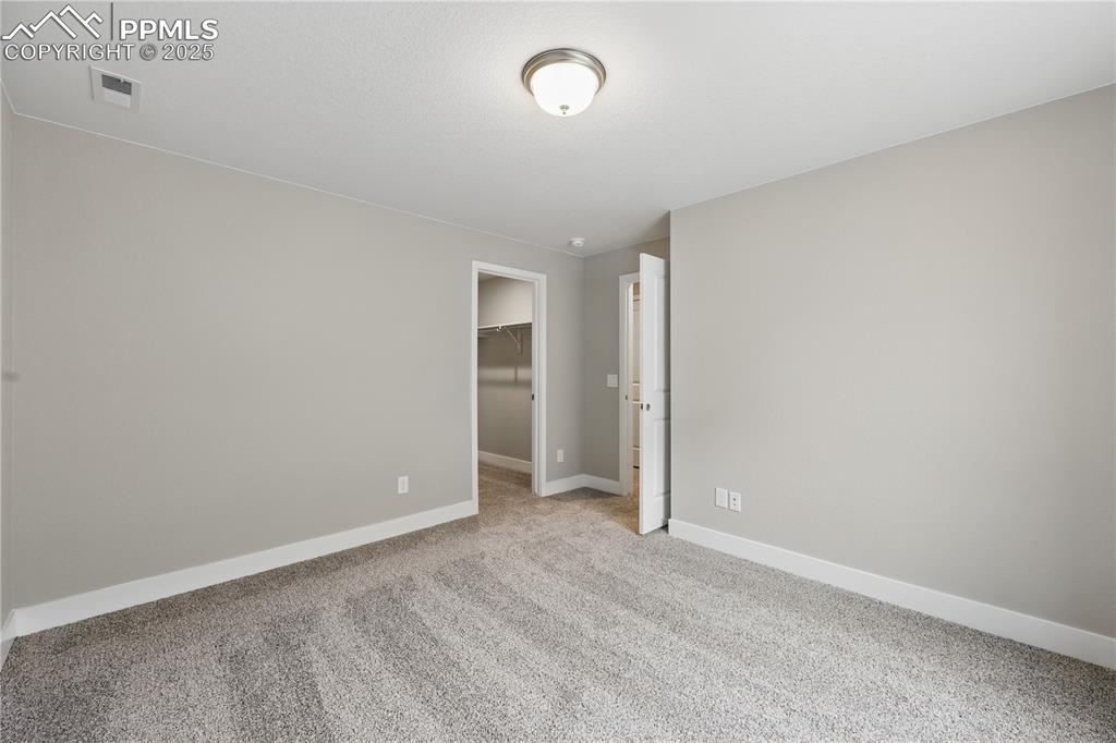 Image 33 of 35: Carpeted empty room with baseboards and visible vents