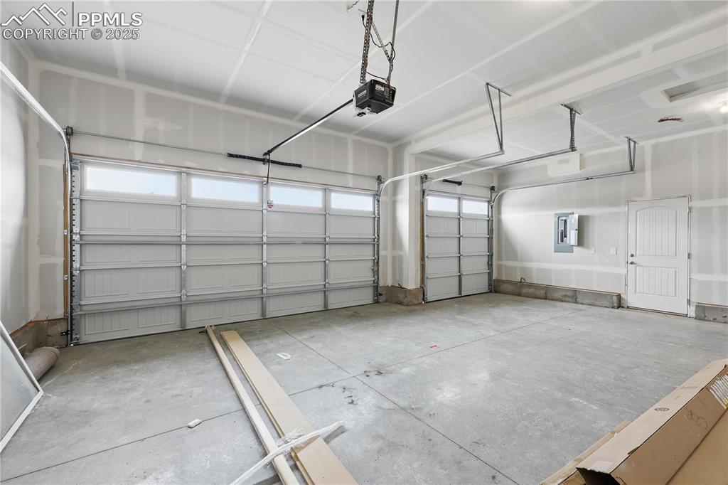 Image 34 of 35: Garage featuring electric panel and a garage door opener