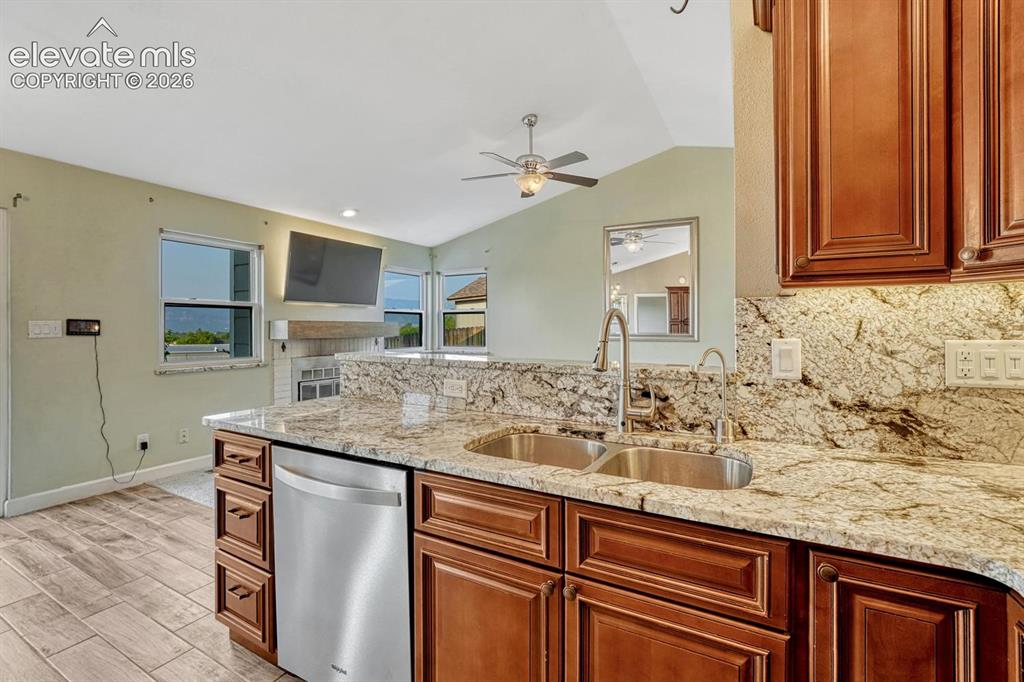 Image 12 of 50: Kitchen with granite counter and cherry cabinets