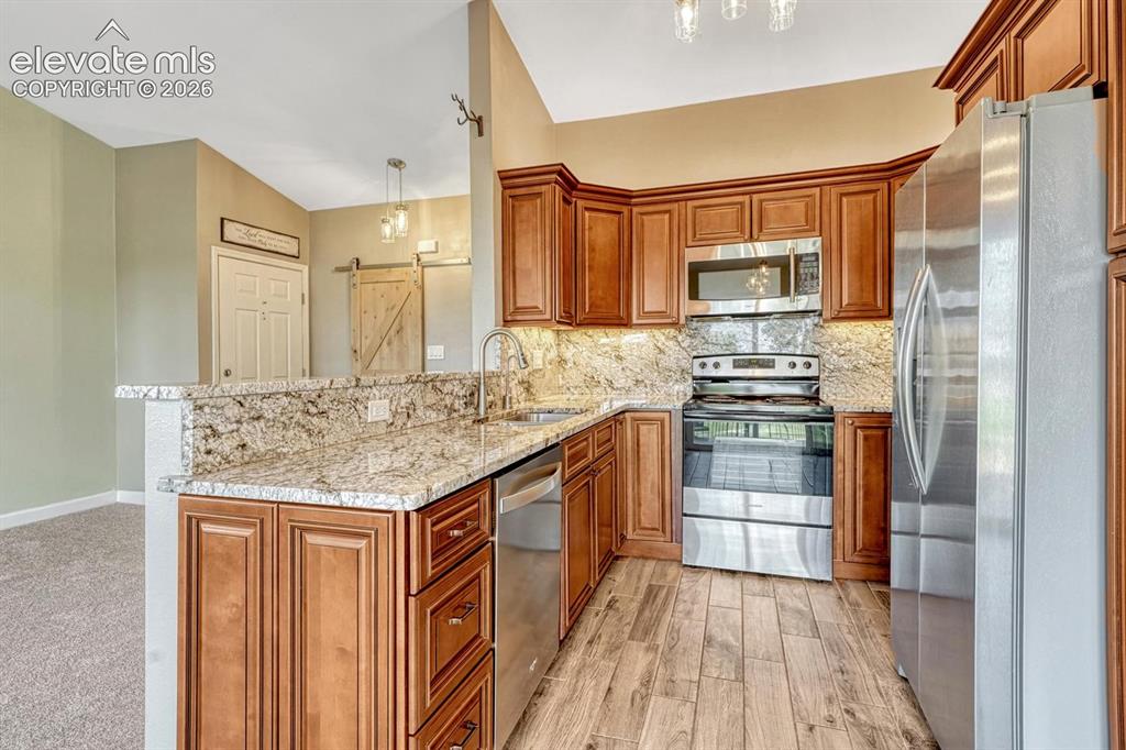 Image 16 of 50: Stainless steel appliances and tile floor