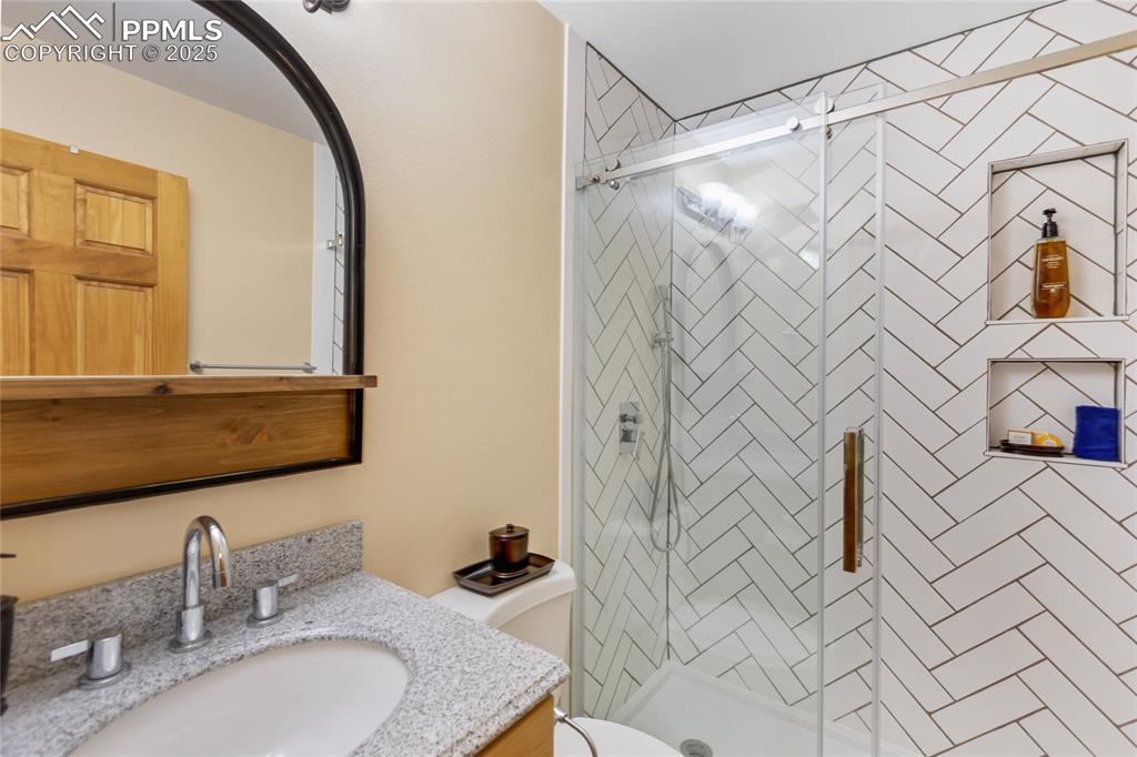 Image 12 of 50: Bathroom with vanity and a stall shower