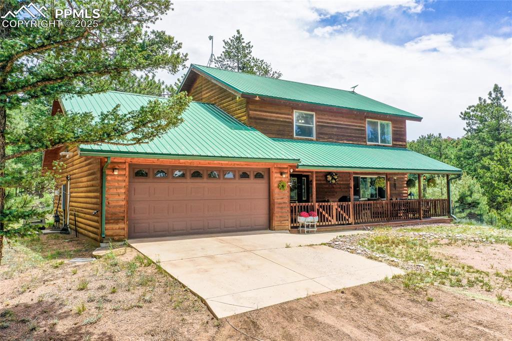 Image 14 of 50: View of front facade featuring a porch, driveway, an attached garage, and a