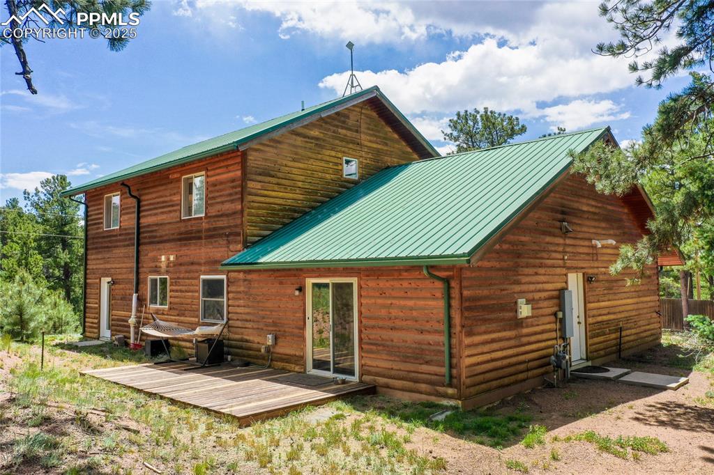 Image 16 of 50: Back of property featuring a deck and a metal roof