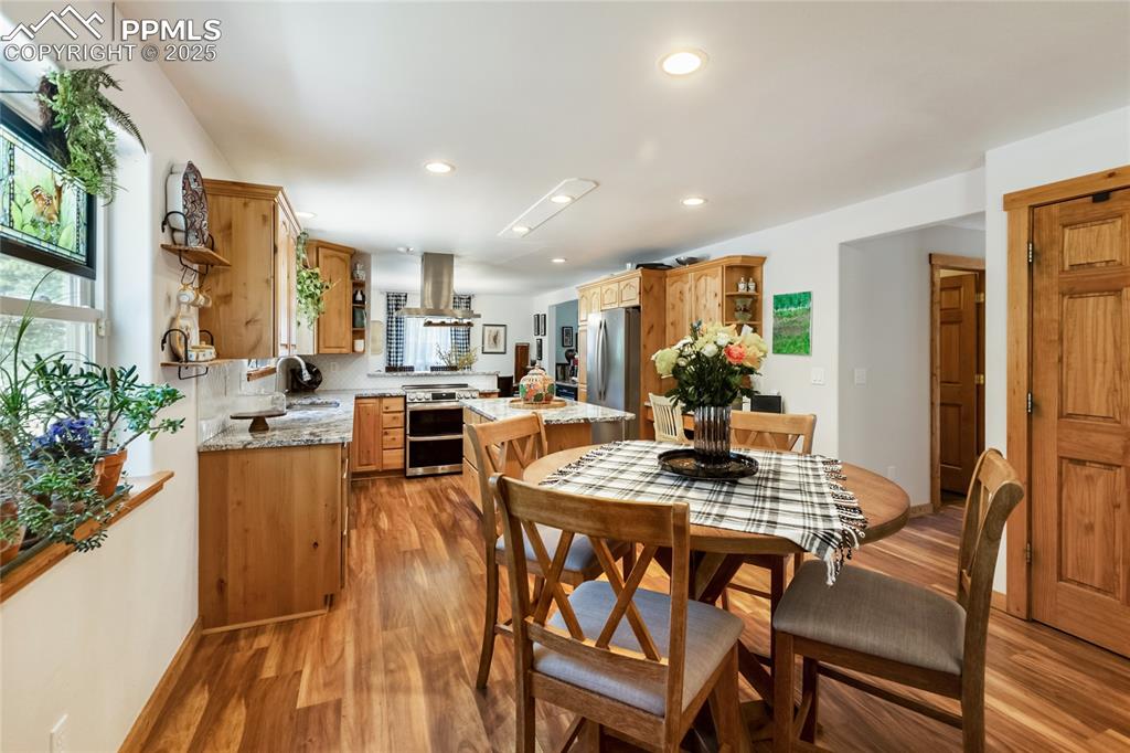Image 27 of 50: Dining room featuring light wood-style floors and recessed lighting