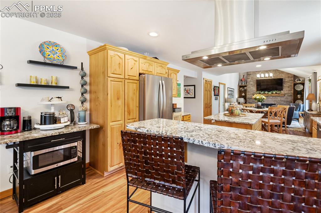 Image 34 of 50: Kitchen featuring appliances with stainless steel finishes, light wood fini