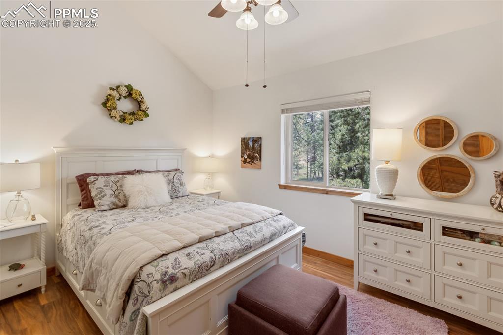 Image 40 of 50: Bedroom with vaulted ceiling, wood finished floors, and ceiling fan