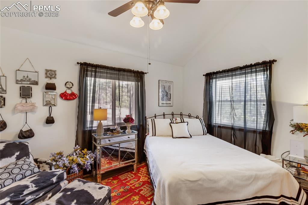 Image 43 of 50: Bedroom with lofted ceiling, ceiling fan, and wood finished floors