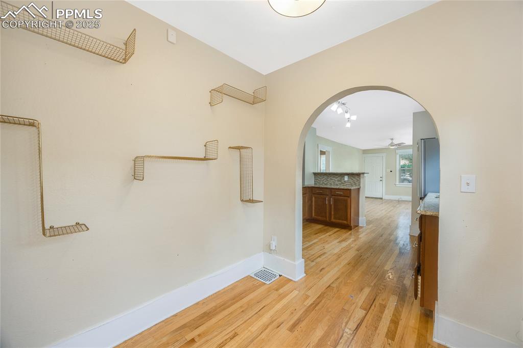 Image 14 of 28: Corridor featuring arched walkways and light wood-style flooring