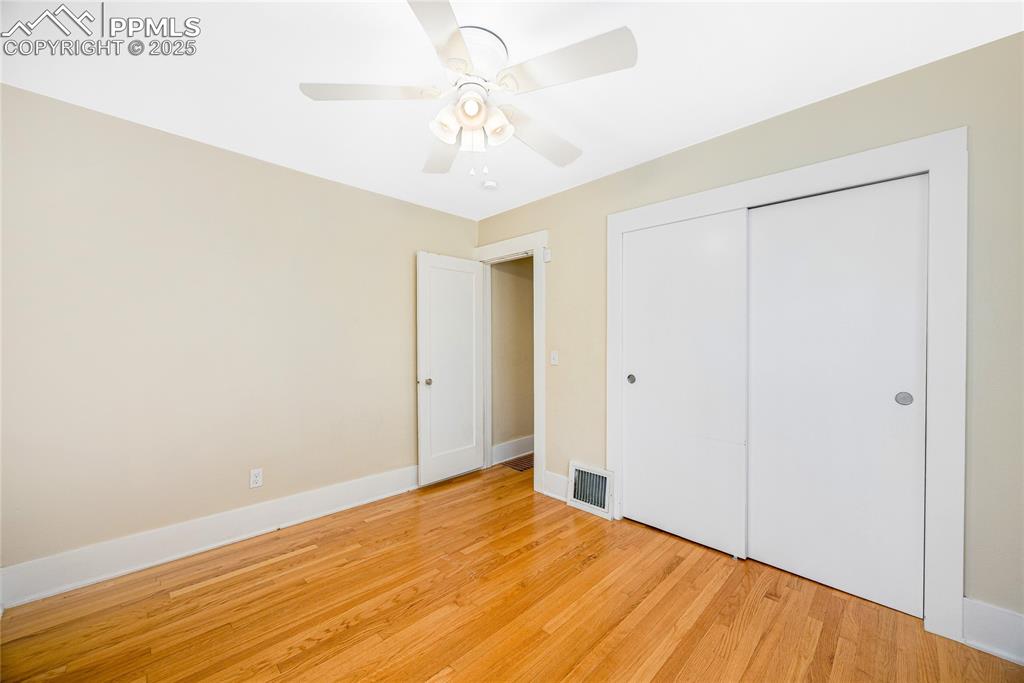 Image 16 of 28: Unfurnished bedroom with light wood-type flooring, a ceiling fan, and a clo