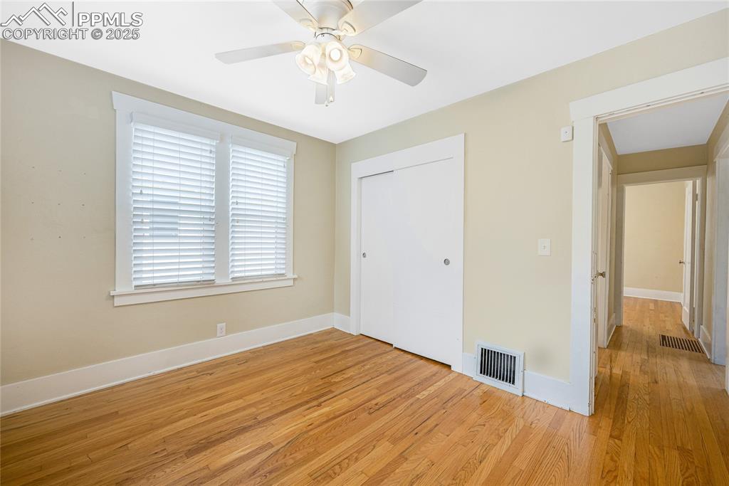 Image 19 of 28: Unfurnished bedroom with light wood-style floors, ceiling fan, and a closet