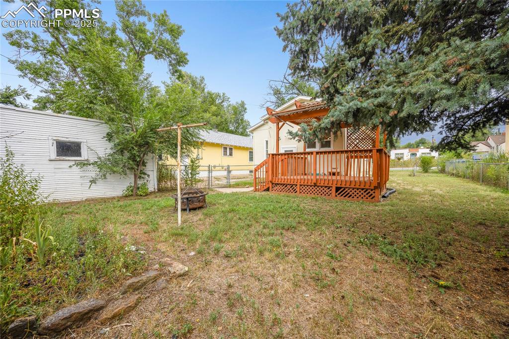 Image 24 of 28: View of yard with a deck and a fire pit
