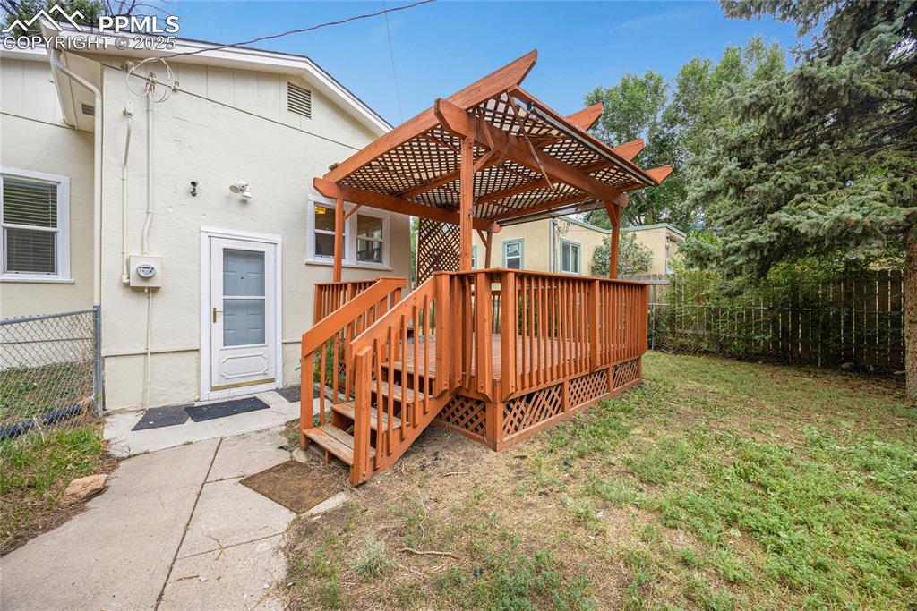 Image 25 of 28: Wooden deck featuring a fenced backyard