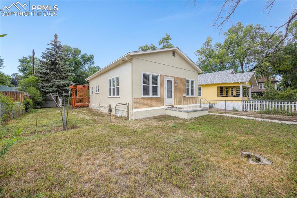 Image 3 of 28: View of front facade with a fenced backyard, brick siding, and stucco sidin