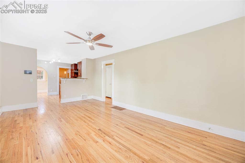 Image 6 of 28: Unfurnished living room featuring light wood-type flooring and a ceiling fa