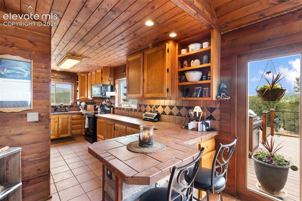 Image 14 of 44: Log staircase and Front entry viewed from dining room