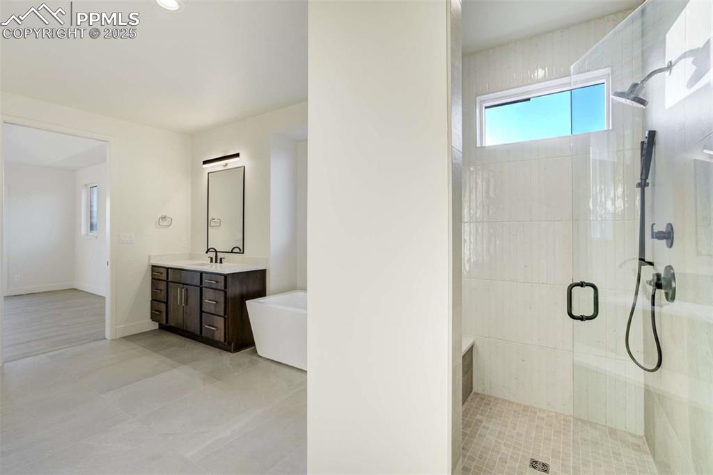Image 16 of 34: Full bath featuring a stall shower, vanity, a freestanding bath, and light