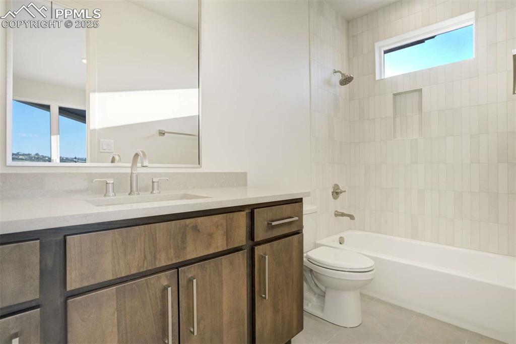 Image 19 of 34: Full bath featuring shower combination, vanity, and light tile patterned f
