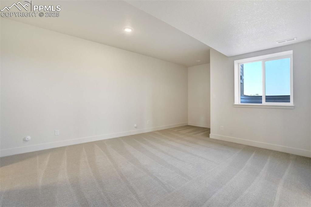 Image 25 of 34: Unfurnished room featuring light carpet, a textured ceiling, and recessed l