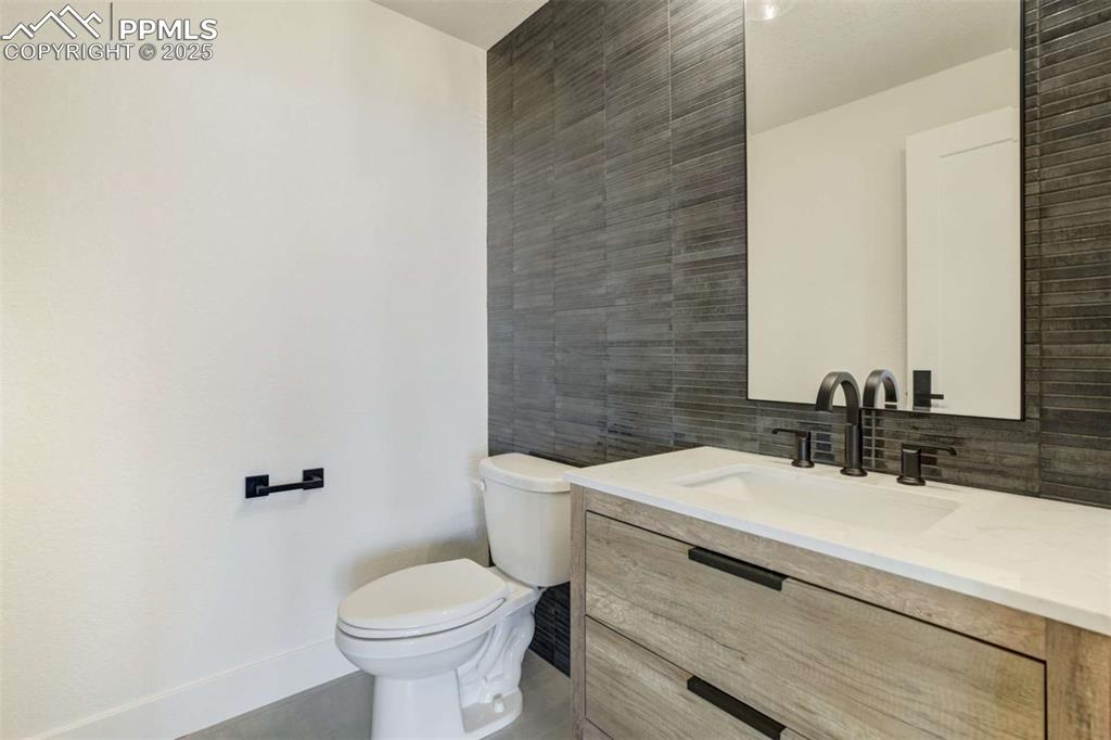 Image 35 of 40: Bathroom featuring tile walls, vanity, and backsplash
