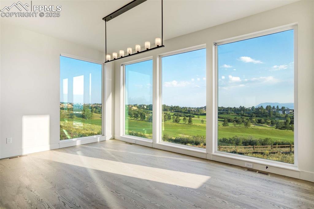 Image 7 of 34: Unfurnished dining area featuring light wood finished floors, a mountain vi
