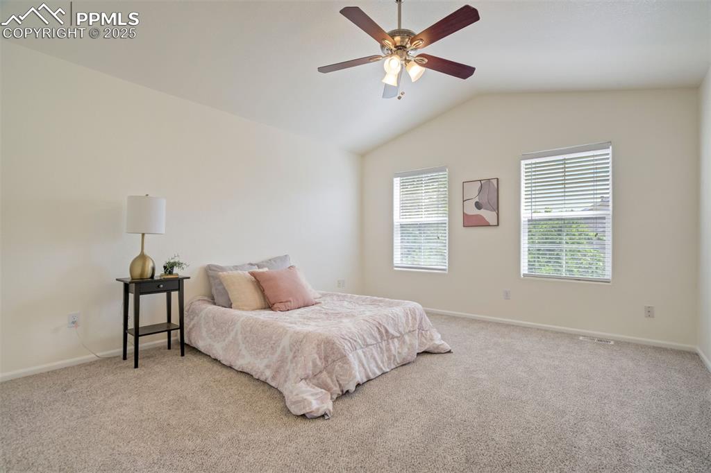 Image 18 of 38: Primary bedroom with soaring ceilings and abundant natural light