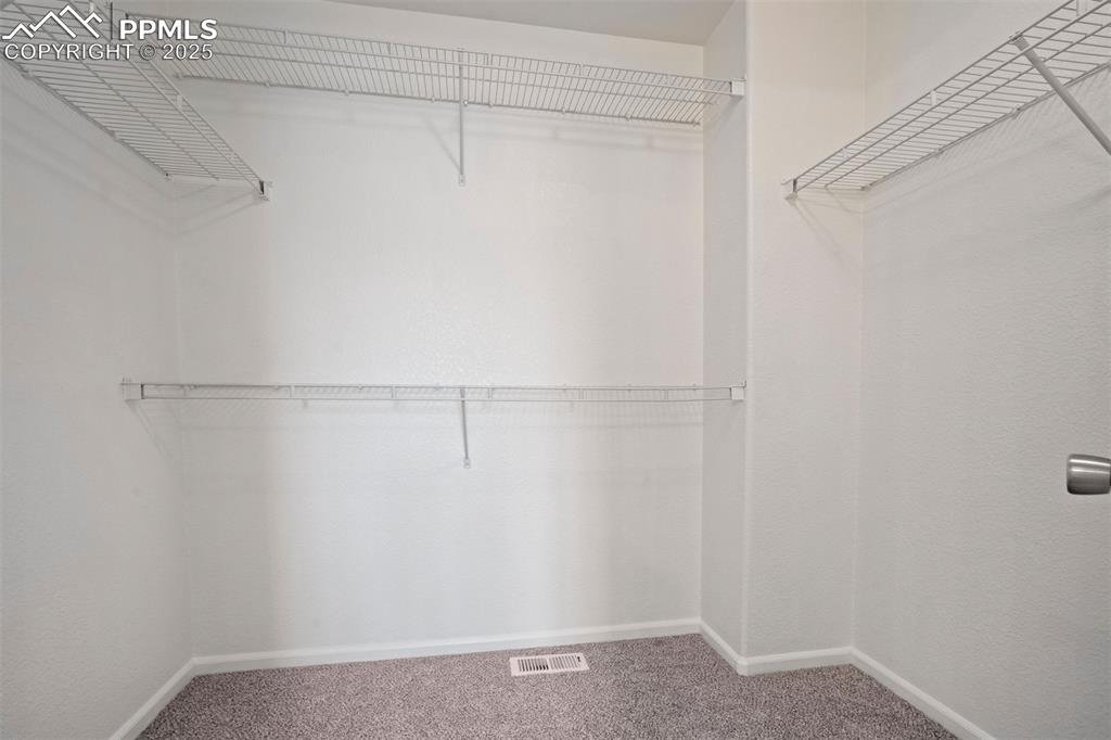 Image 22 of 38: large walk-in closet off of primary bathroom