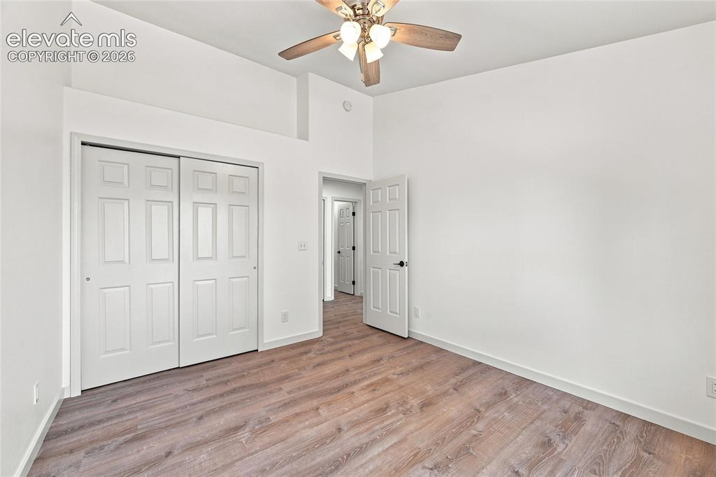 Image 12 of 30: Wood-finish flooring, white walls, and a ceiling fan with integrated lighti