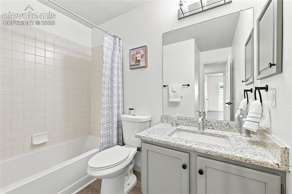 Image 13 of 30: Bathroom featuring a tub/shower combination with white tile surround, a van