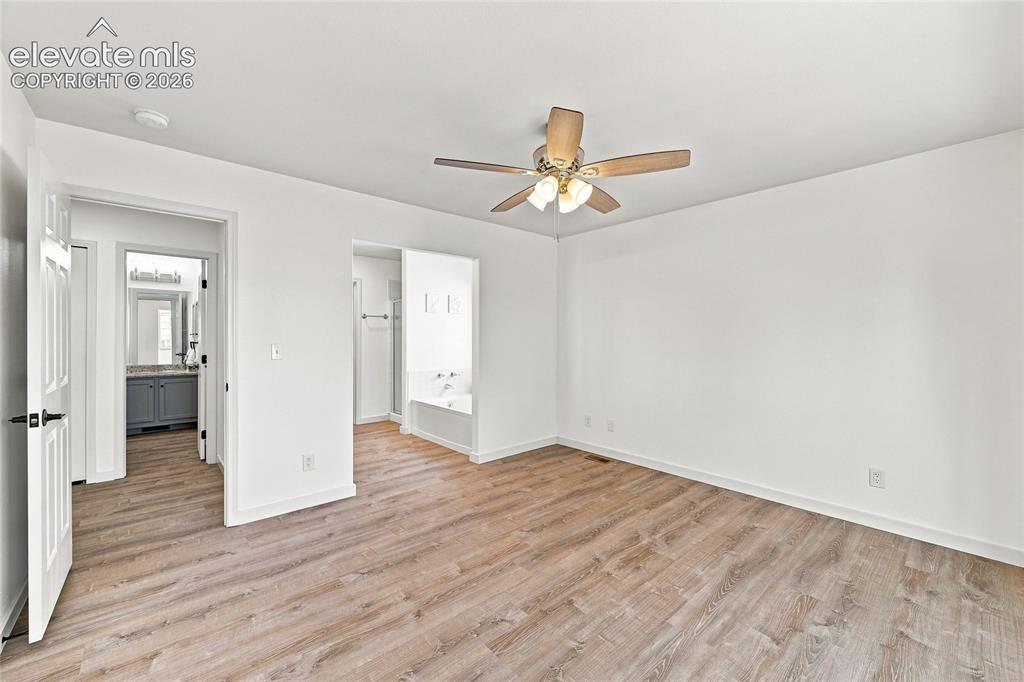 Image 15 of 30: Light wood-finish flooring, ceiling fan with integrated lighting, recessed 