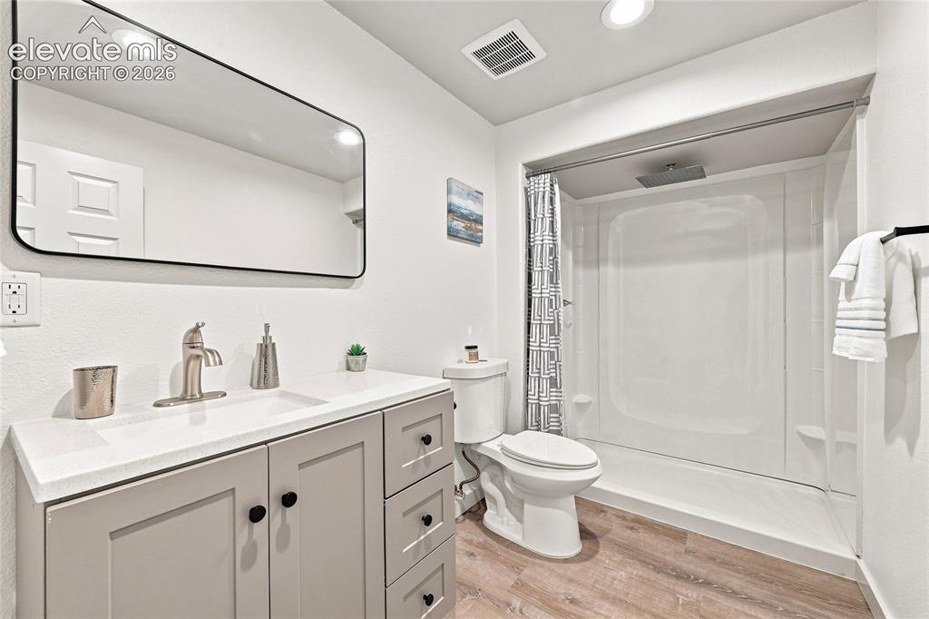 Image 23 of 30: Vanity with a white countertop and integrated sink, brushed nickel faucet,