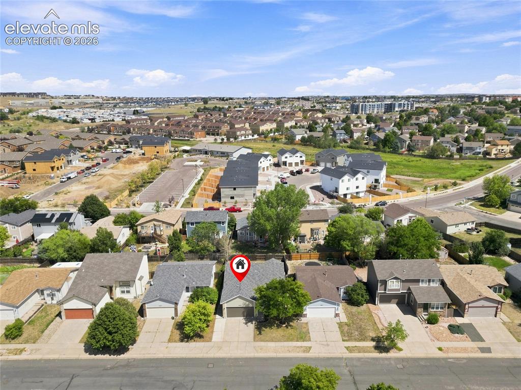 Image 27 of 30: Single-family residence with an attached garage, paved driveway, and mature