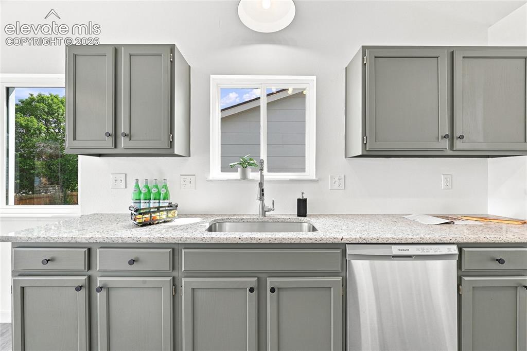 Image 3 of 30: Gray shaker-style cabinetry with dark hardware, stainless steel sink with c