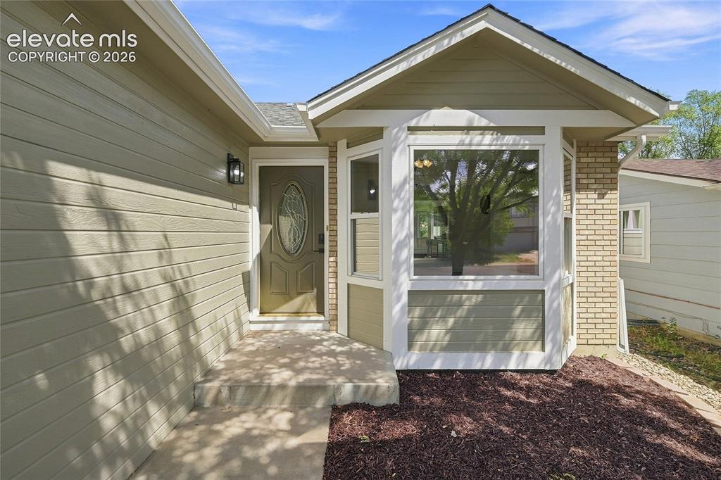 Image 5 of 30: Exterior featuring light-colored horizontal siding, a bay window with a whi