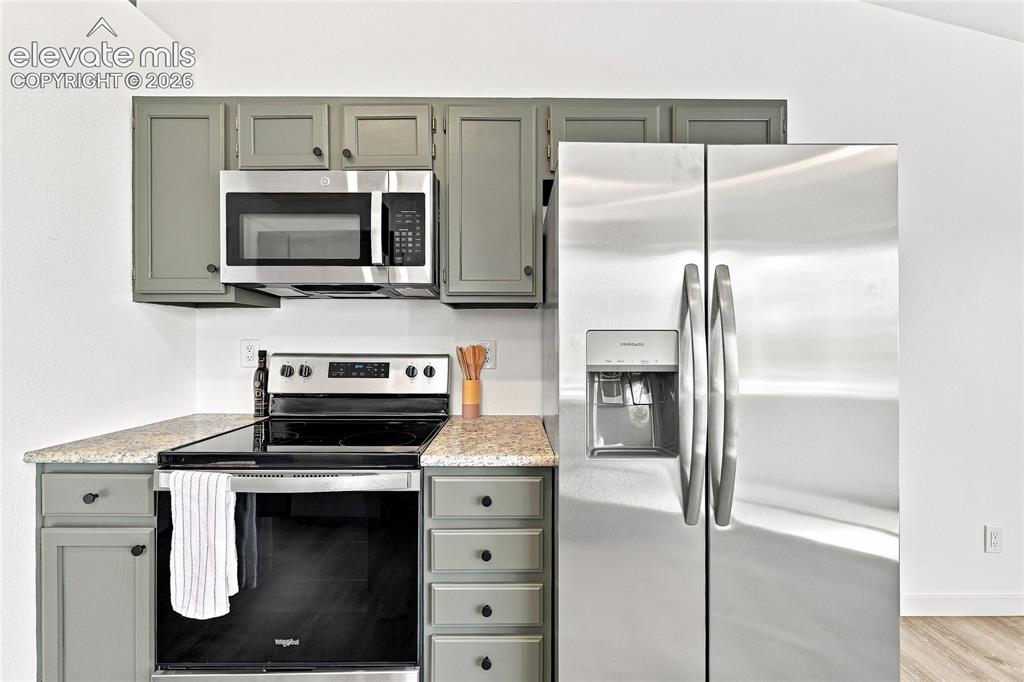 Image 8 of 30: Kitchen featuring stainless steel appliances, grey cabinetry, light-colored