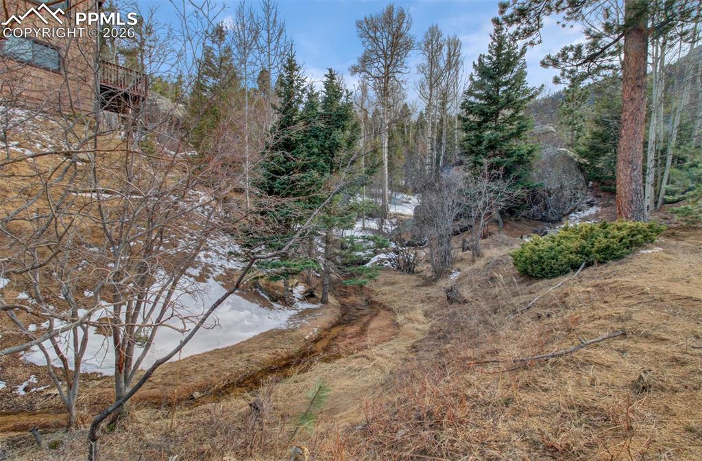 Image 38 of 45: Spring fed stream on the side of the home! Year around enjoyment of sound o