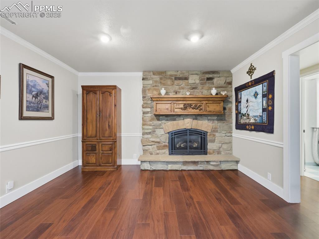 Image 29 of 47: basement family room has a stone fireplace.