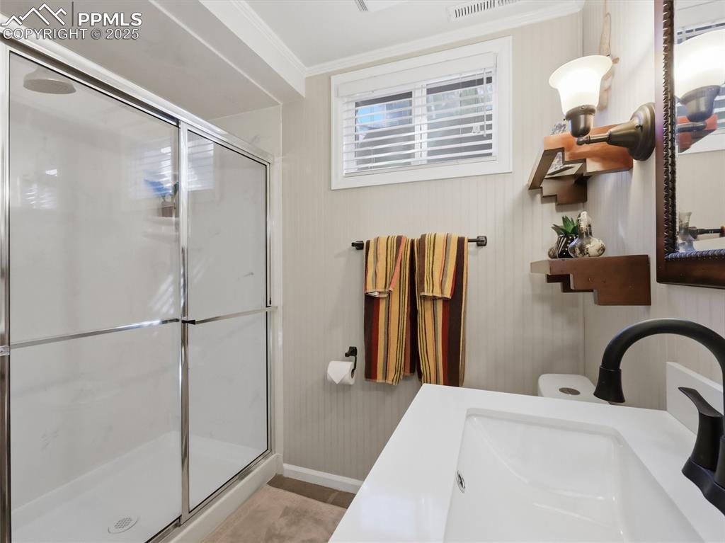 Image 32 of 47: Basement bathroom has a large shower with sliding glass door