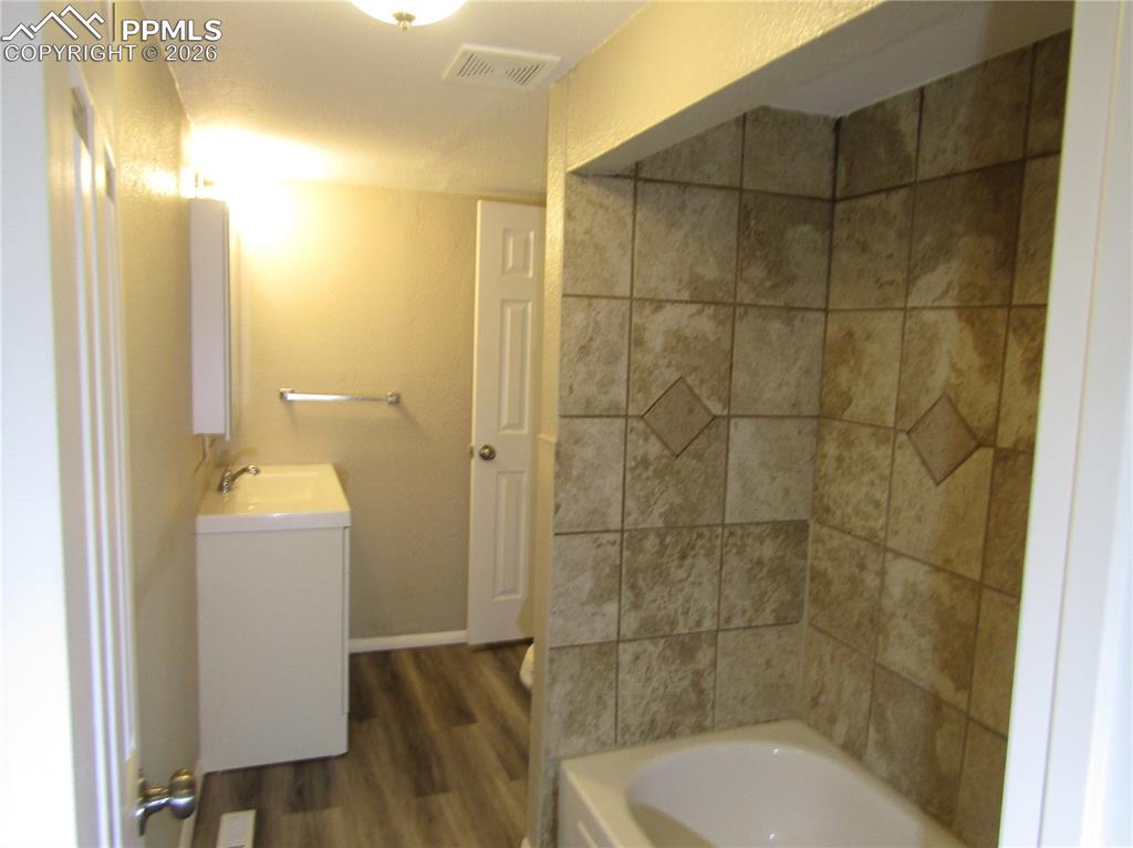 Image 19 of 21: Bathroom featuring vanity and dark wood-style flooring