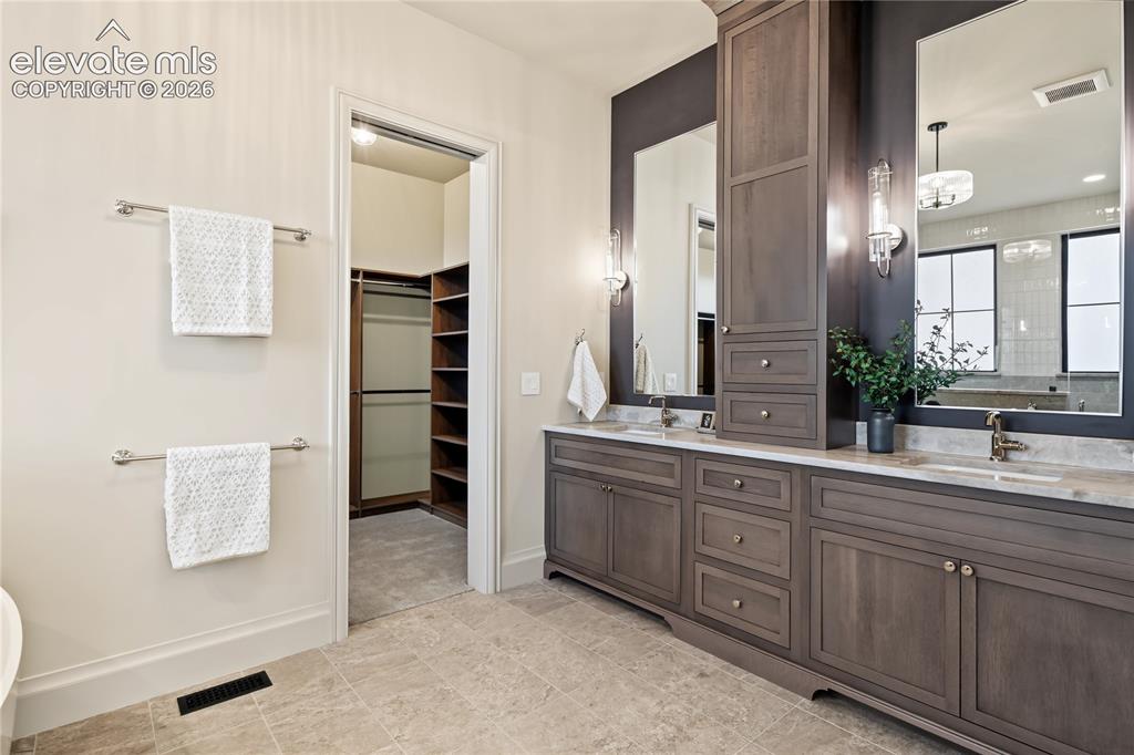 Image 13 of 50: Primary bathroom with custom walk-in closet
