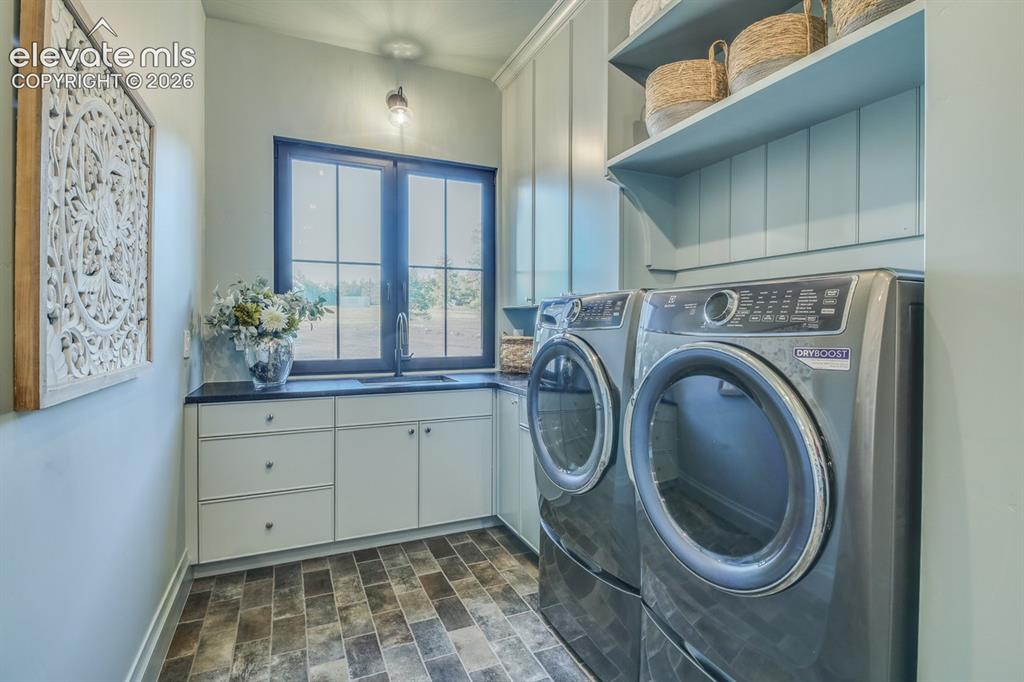 Image 21 of 50: This laundry room has it all, lots of cabinets, storage and sink.