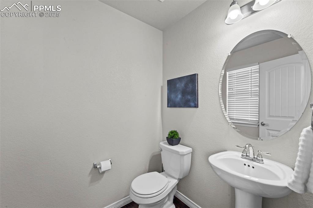 Image 19 of 29: Half bathroom featuring baseboards, a sink, and toilet