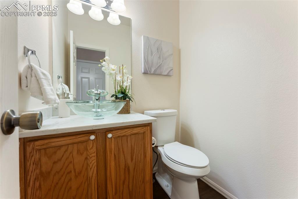Image 11 of 50: Half bathroom with vanity and toilet