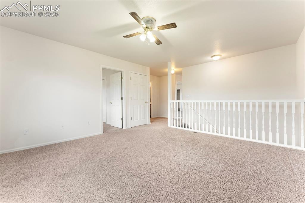 Image 12 of 50: Carpeted empty room with baseboards and ceiling fan