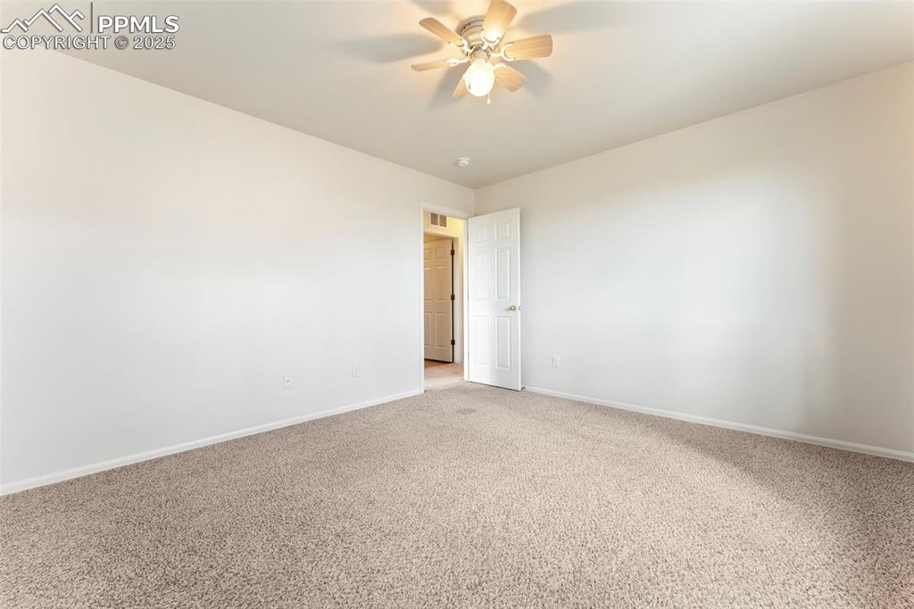 Image 25 of 50: Carpeted spare room with baseboards and ceiling fan