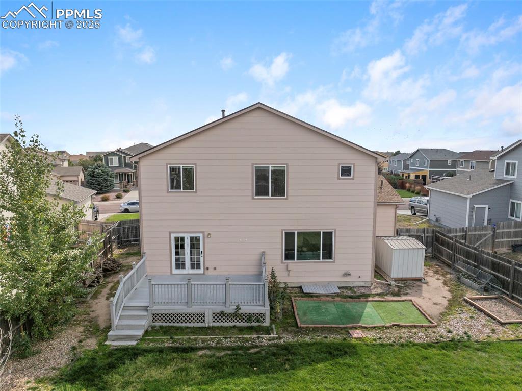 Image 44 of 50: Back of house featuring a fenced backyard, a residential view, and a deck