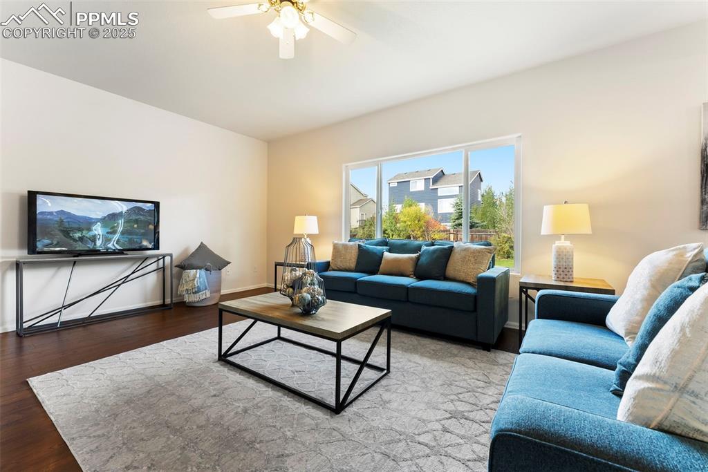 Image 9 of 50: Living room featuring wood finished floors and ceiling fan